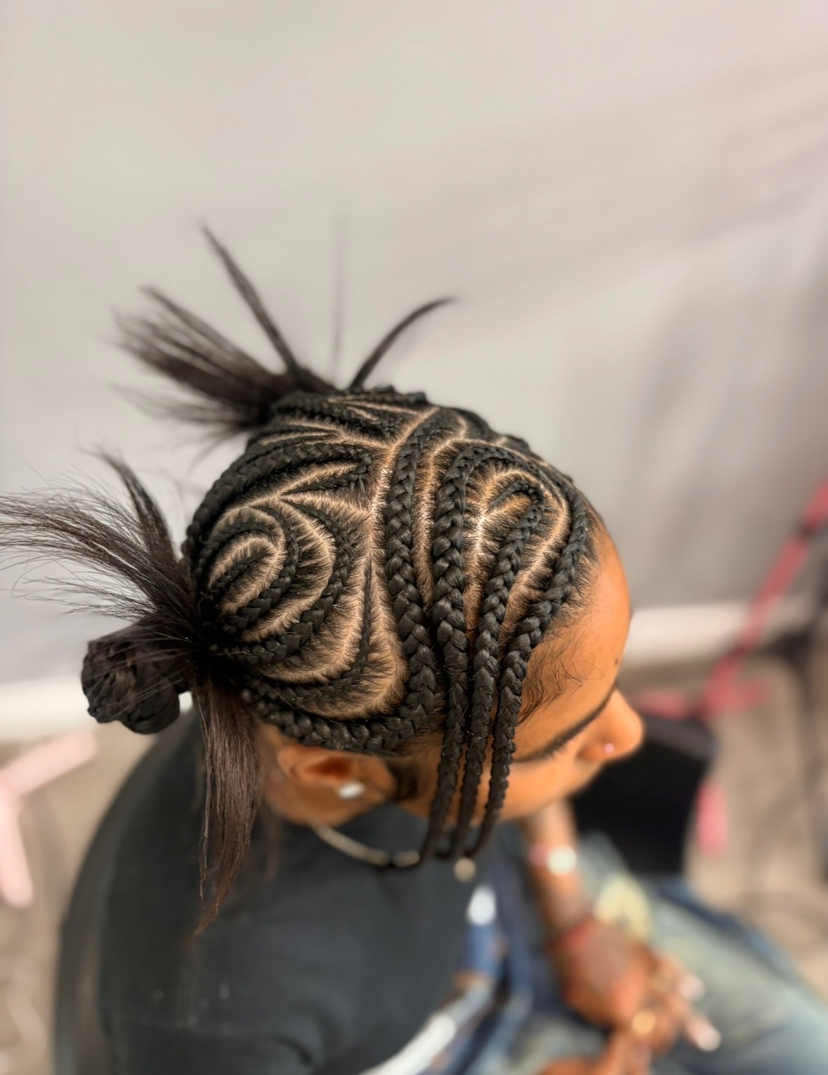 Intricate freestyle cornrow pattern on natural hair, close-up overhead view showing detailed scalp work